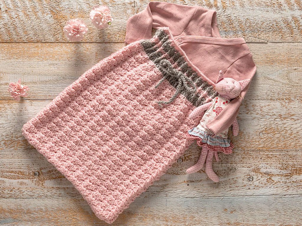 Gehäkelter Schlafsack in Rosa mit grauem Kordelbund als Häkelprojekt-Idee