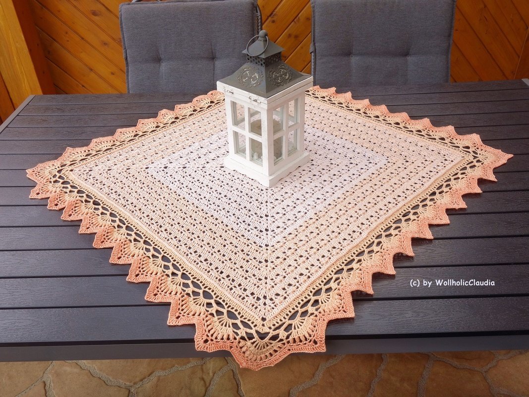 Quadratisches, gehäkeltes Tischdeckchen in Creme und Pfirsich mit weißer Laterne auf dunklem Holztisch