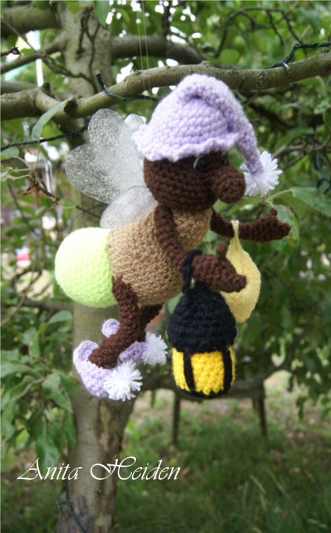 Gehäkeltes Glühwürmchen-Amigurumi mit Laterne und lila Mütze