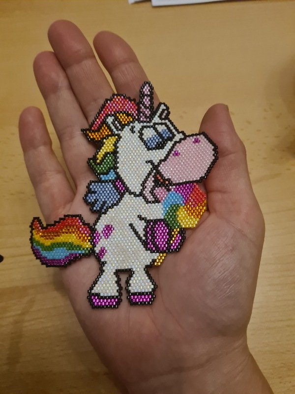 Gefädelter Perlen-Einhorn-Anhänger mit Regenbogenmähne in einer Hand