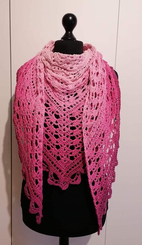 Gehäkeltes Dreieckstuch in Rosa-Farbverlauf mit Spitzenmuster auf schwarzer Schneiderpuppe