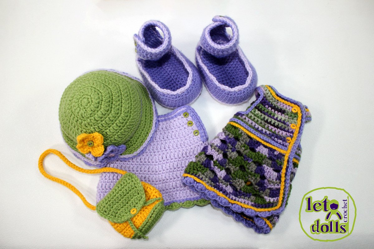 Crochet doll outfit set: green hat with yellow flower, lavender shoes, lavender top, multicolored vest, and small purse on white background
