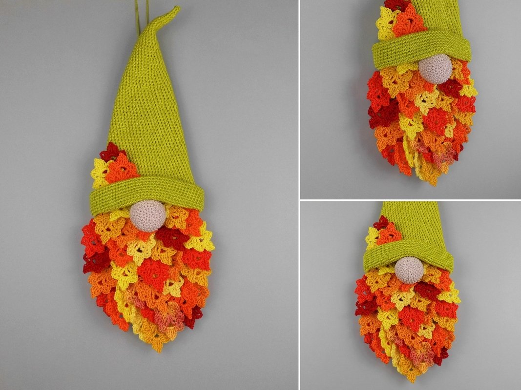 Crocheted gnome with bright green hat and multicolored leaf-beard on a gray background.