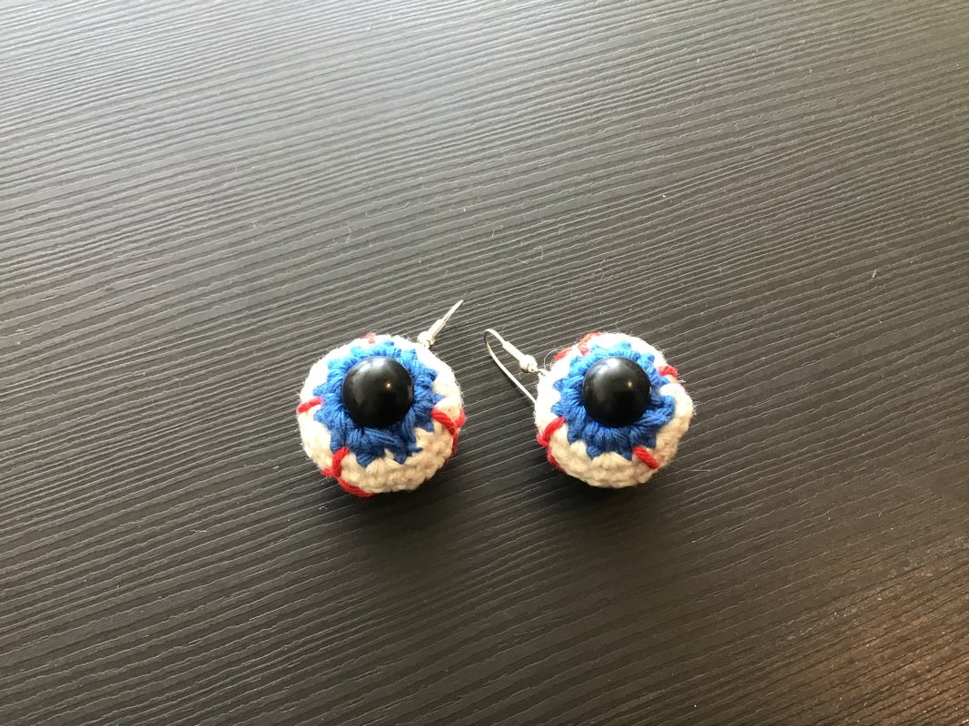 Handgefertigte gehäkelte Augen-Ohrringe mit blauer Iris, weißer Umrandung und schwarzer Perle