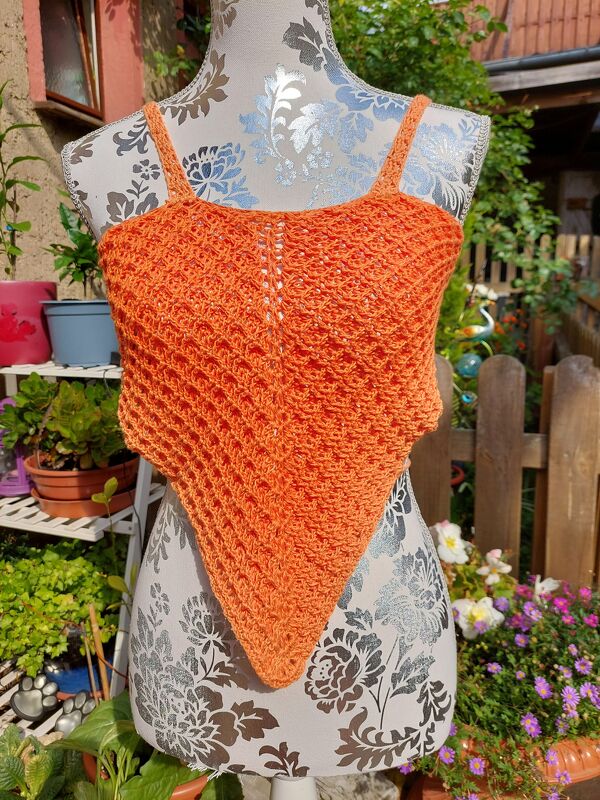 Oranges gehäkeltes Bandana-Top mit dünnen Trägern auf Schaufensterpuppe im Garten