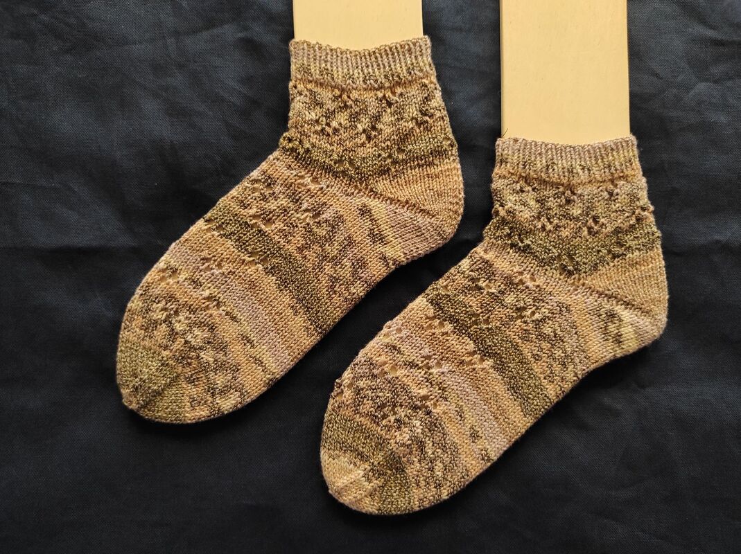 Paar knöchelhoher, gestrickter Damensocken in braun-melierten Tönen auf Sockenspannern