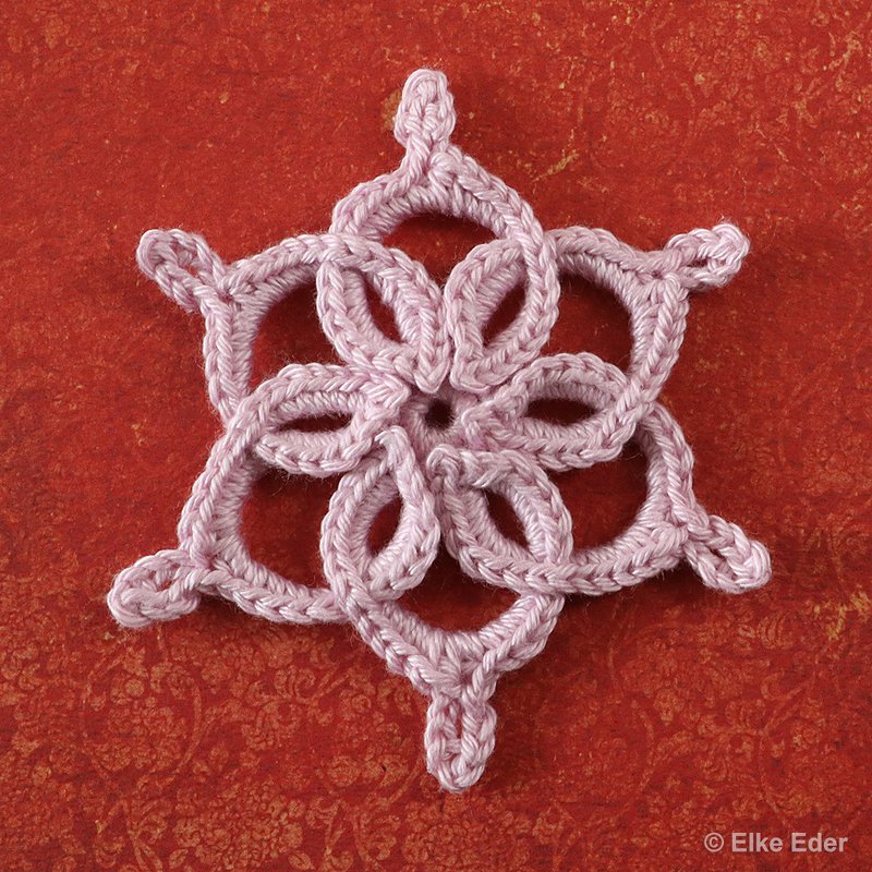Pale pink six-point crochet motif showing looped petals and picot tips