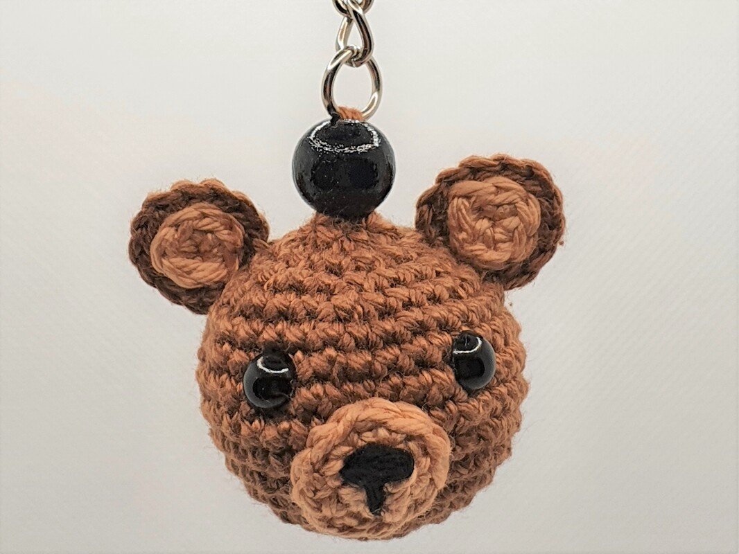 Gehäkelter brauner Teddybär‑Schlüsselanhänger mit schwarzen Perlenaugen an Metallring