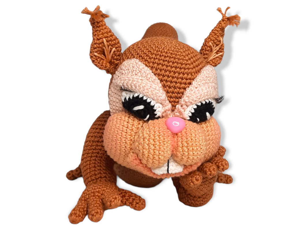 Gehäkeltes Amigurumi in Braun mit Wimpern, rosa Knopfnase und großen Backen