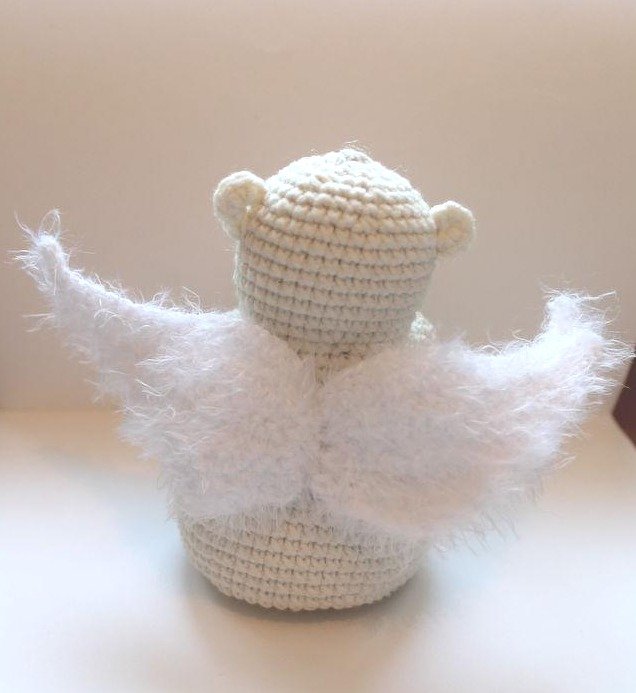 Cremeweißes gehäkeltes Amigurumi‑Engelchen mit flauschigen weißen Flügeln, Rückansicht