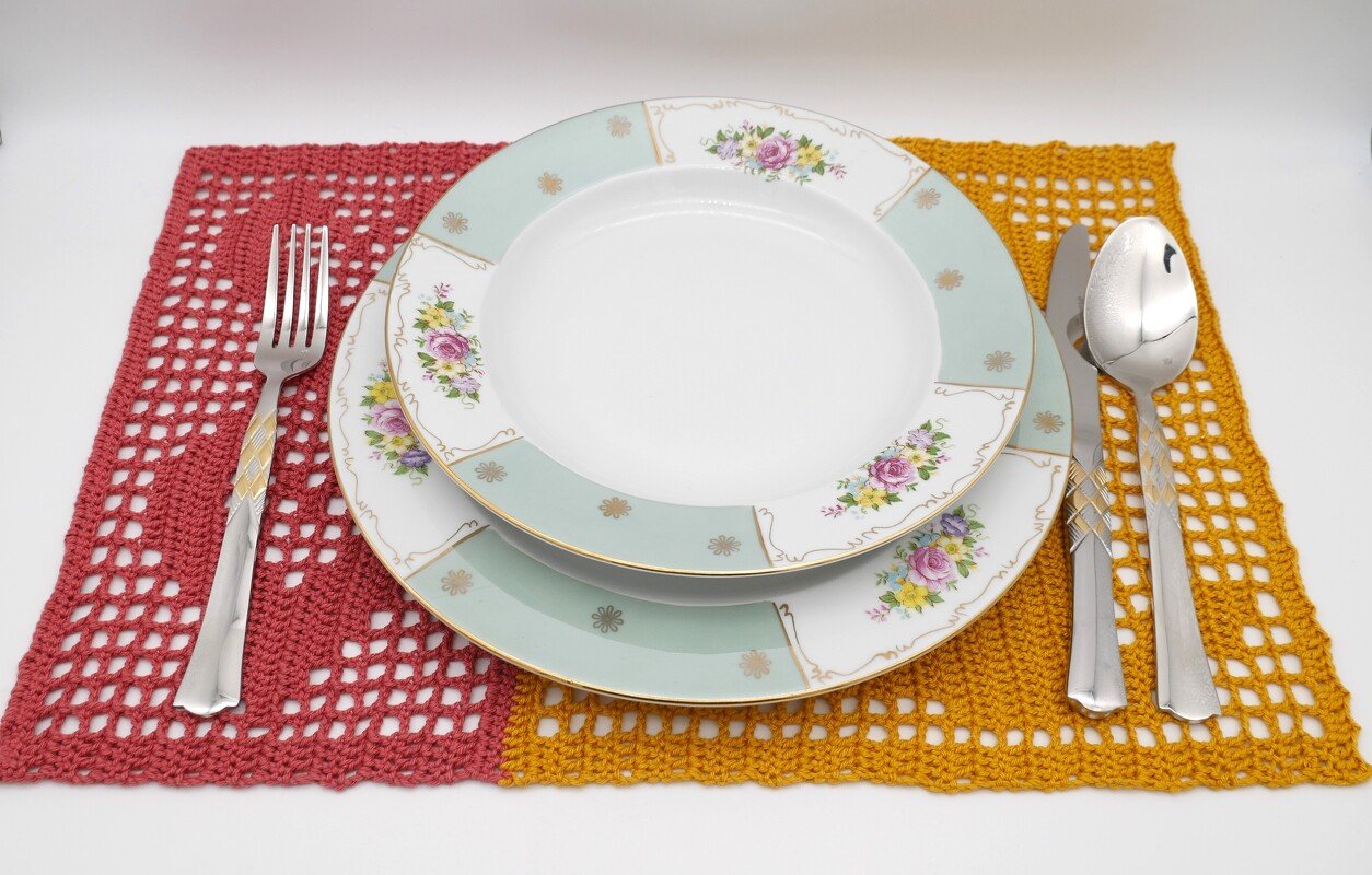 Zweifarbiges gehäkeltes Platzset mit Gedeck und Blumengeschirr