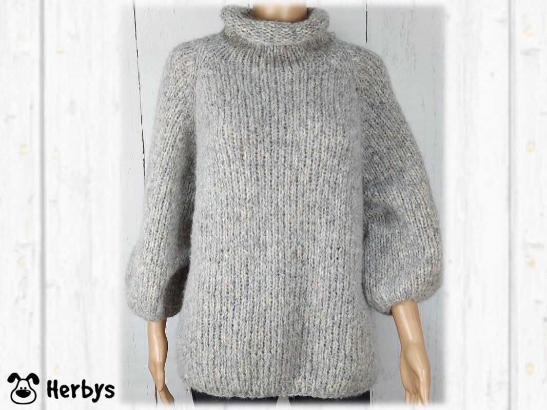 Hellgrauer Damen-Strickpullover mit hohem Kragen und weiten Ärmeln auf Mannequin