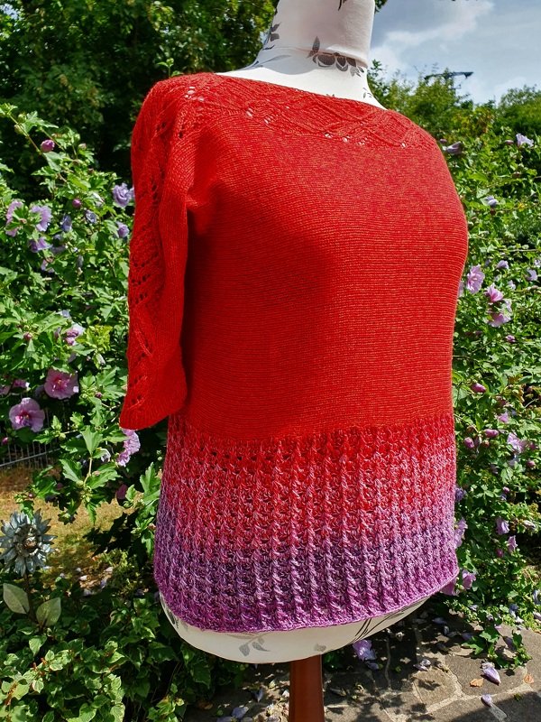 Rotes gestricktes Damen-Shirt mit kurzem Arm und verlaufendem lila Saum auf einer Schaufensterpuppe
