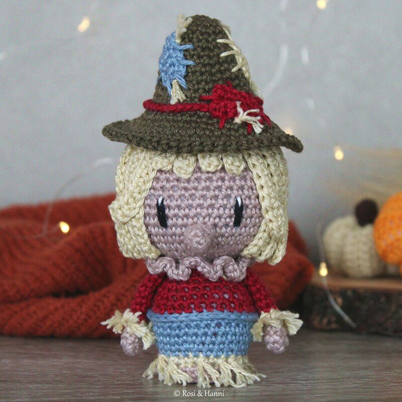 Gehäkelte Amigurumi-Vogelscheuche mit braunem Hut, blonden Haaren und Fransen