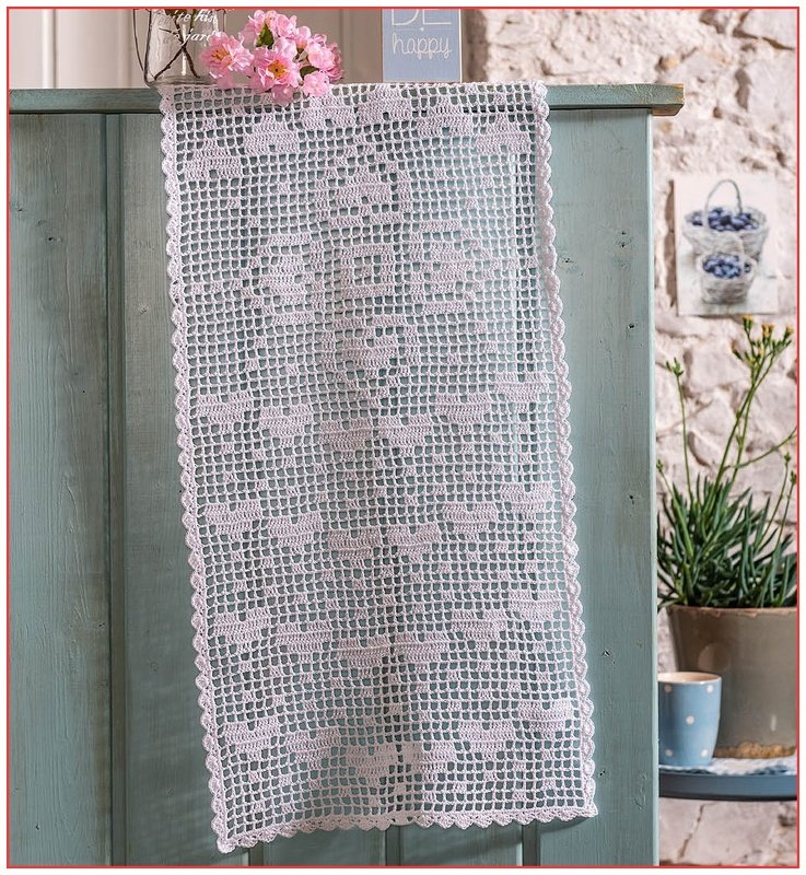 Weißer gehäkelter Tischläufer mit Herz-Filetmuster an hellblauer Kommode