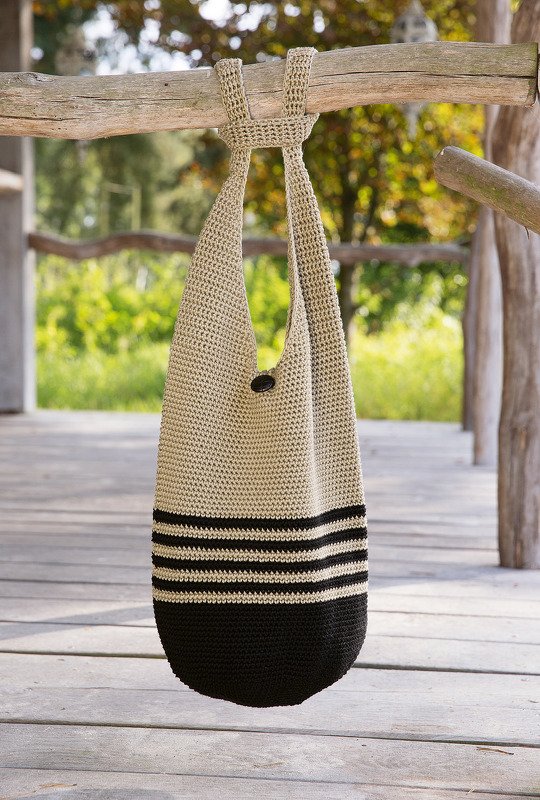 Boho Häkelshopper in Beige mit schwarzen Streifen, hängend im Freien