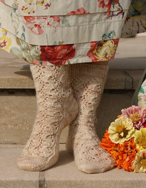 Nahaufnahme beigefarbener Spitzensocken mit Ajourmuster, Fokus auf Maschenbild und Bündchen