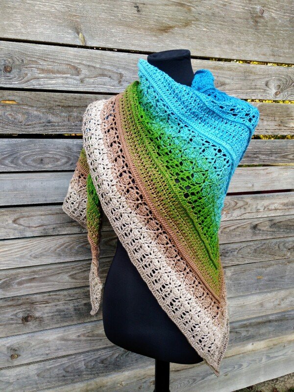 Gehäkeltes dreieckiges Tuch in Blau‑Grün‑Braun mit Spitzenrand auf schwarzer Schaufensterpuppe