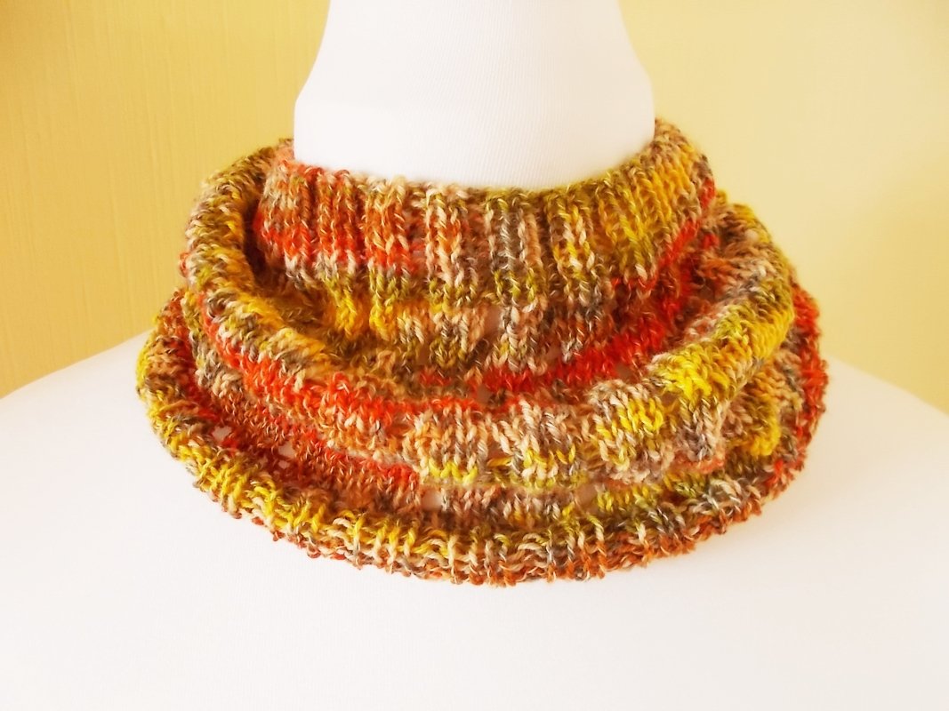 Gestrickter Loop-Schal in Herbstfarben auf weißer Büste