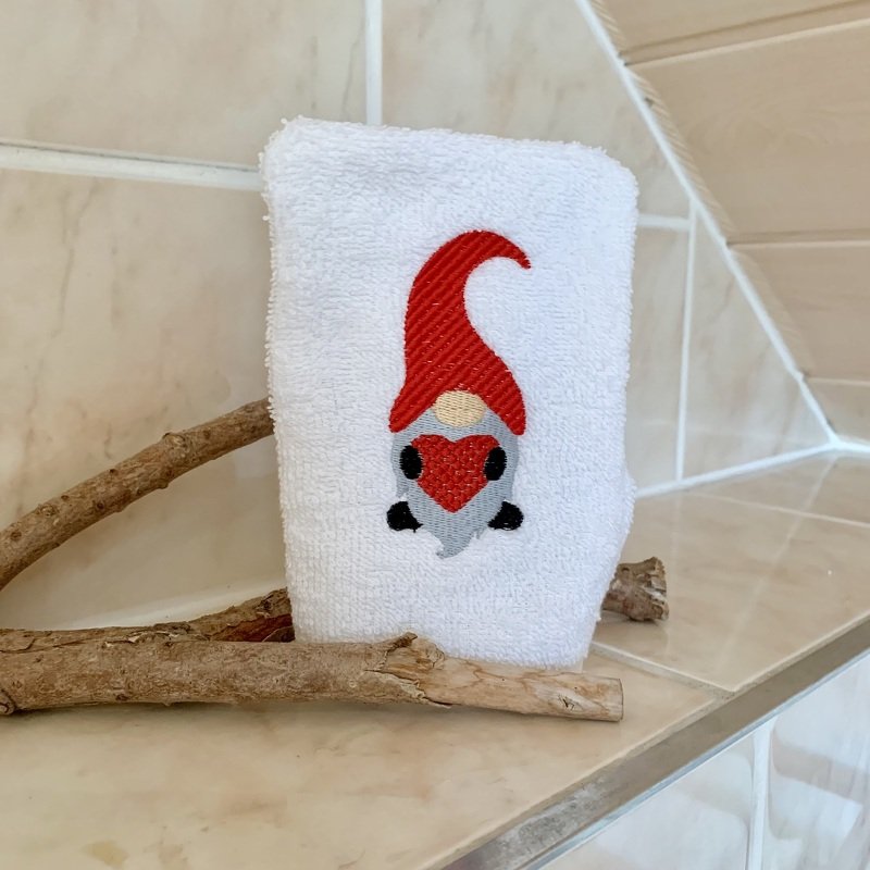 Weißer Waschlappen mit gesticktem Weihnachtswichtel, roter Mütze und rotem Herz