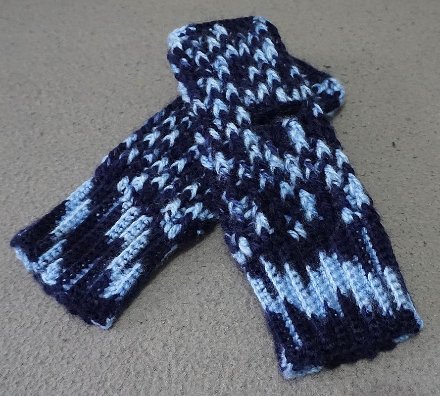 Zwei gehäkelte fingerlose Handschuhe in dunkelblau und hellblau mit geripptem Bündchen
