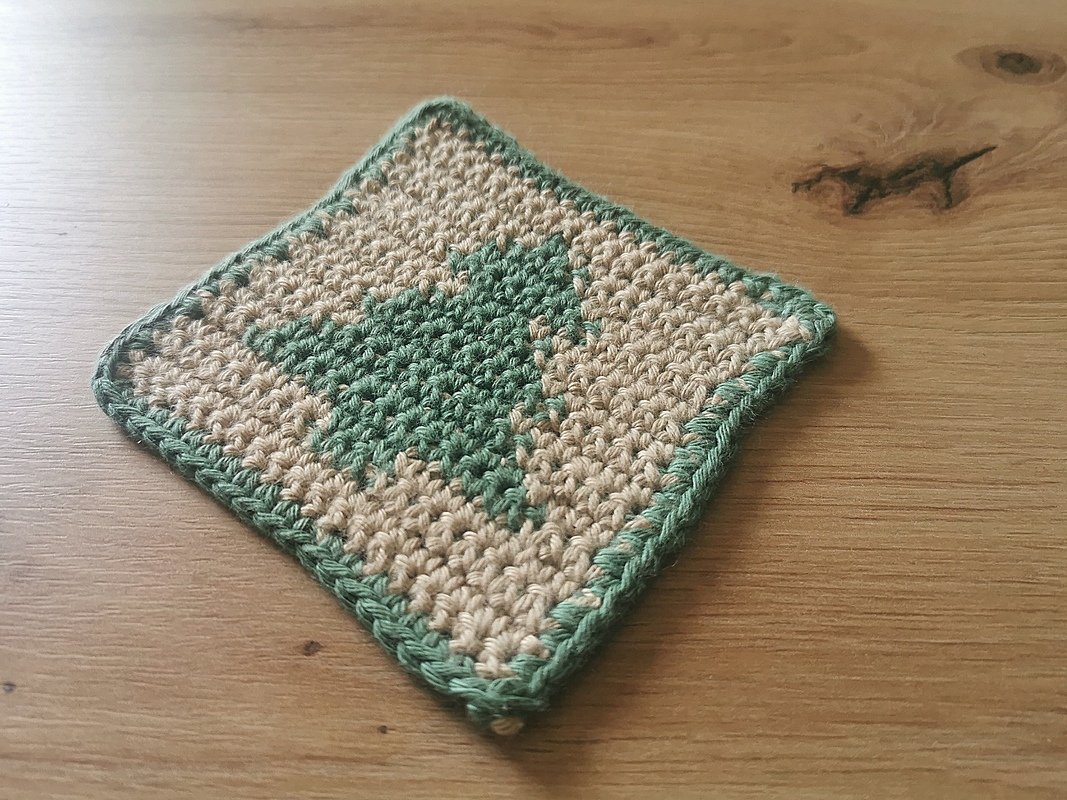 Quadratischer Untersetzer gehäkelt beige mit grünem Baummuster und grüner Einfassung