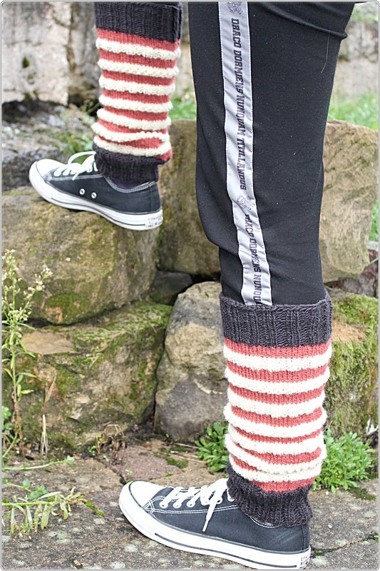 Gestrickte rot-weiß gestreifte Beinstulpen über Leggings, kombiniert mit schwarzen Sneakers
