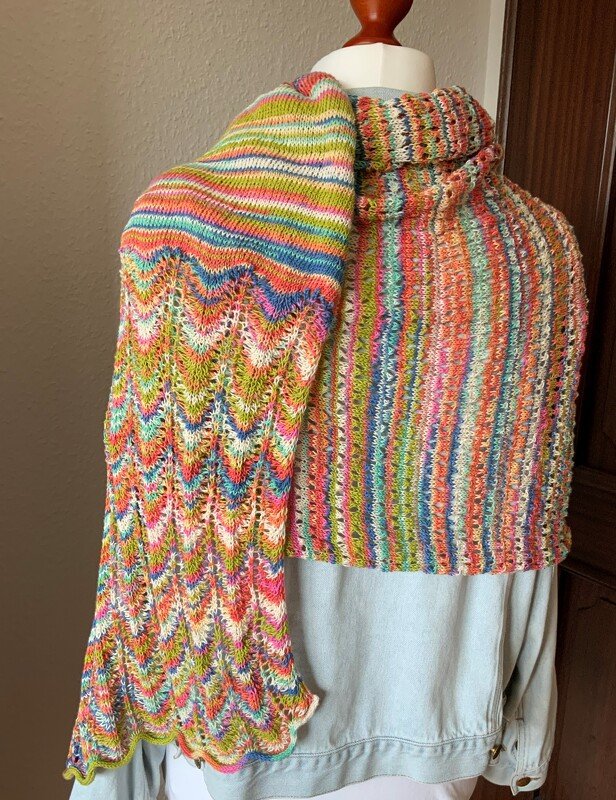 Gestricktes mehrfarbiges Rechtecktuch mit Zickzackmuster auf einer Schaufensterpuppe drapiert.