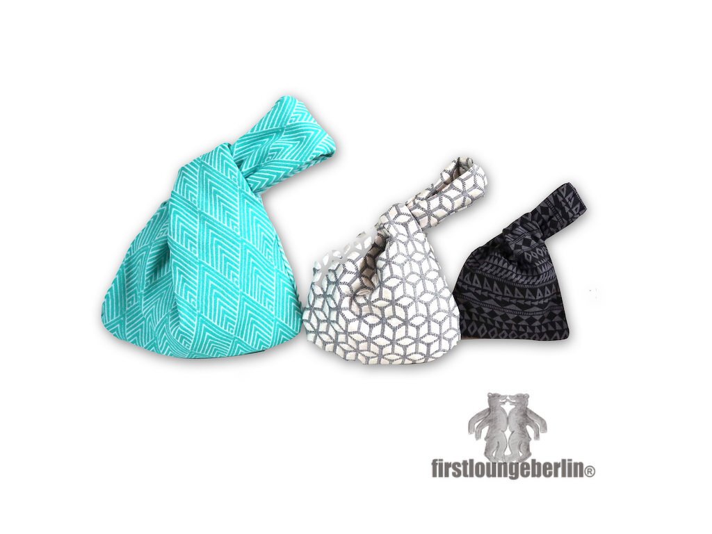 Drei Stoffbeutel mit geknoteten Henkeln in Türkis, Grau-Weiß und Schwarz-Grau auf weißem Hintergrund