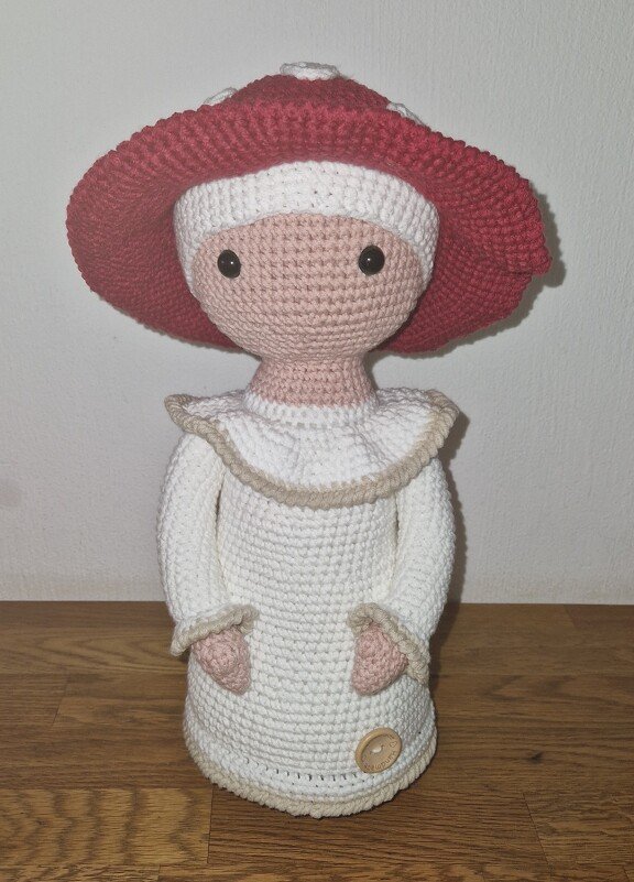 Gehäkelte Amigurumi-Puppe mit großem rotem Hut, weißem Kleid und schwarzen Augen