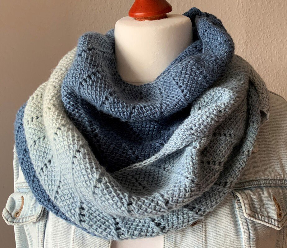 Gehäkelter Loop-Schal in Ombre-Blautönen auf Torso über Jeansjacke