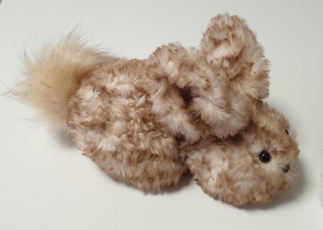Beige-braunes flauschiges Amigurumi-Häschen mit buschigem Schwanz und großen Ohren