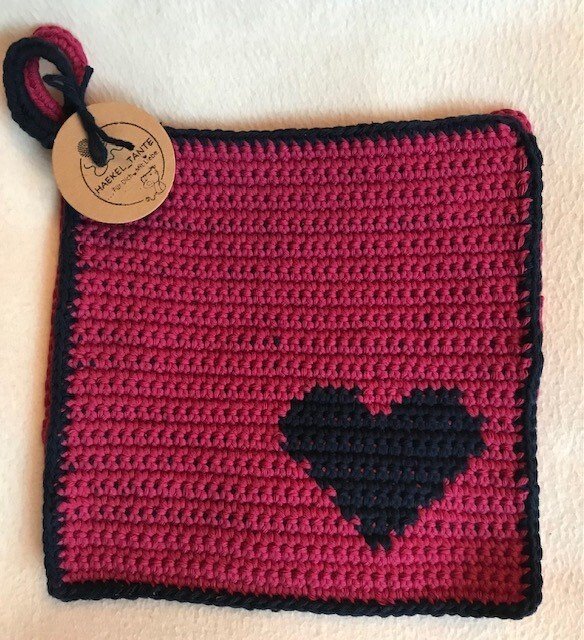 Quadratischer pinker gehäkelter Topflappen mit schwarzem Herz, schwarzem Rand und Aufhängeöse