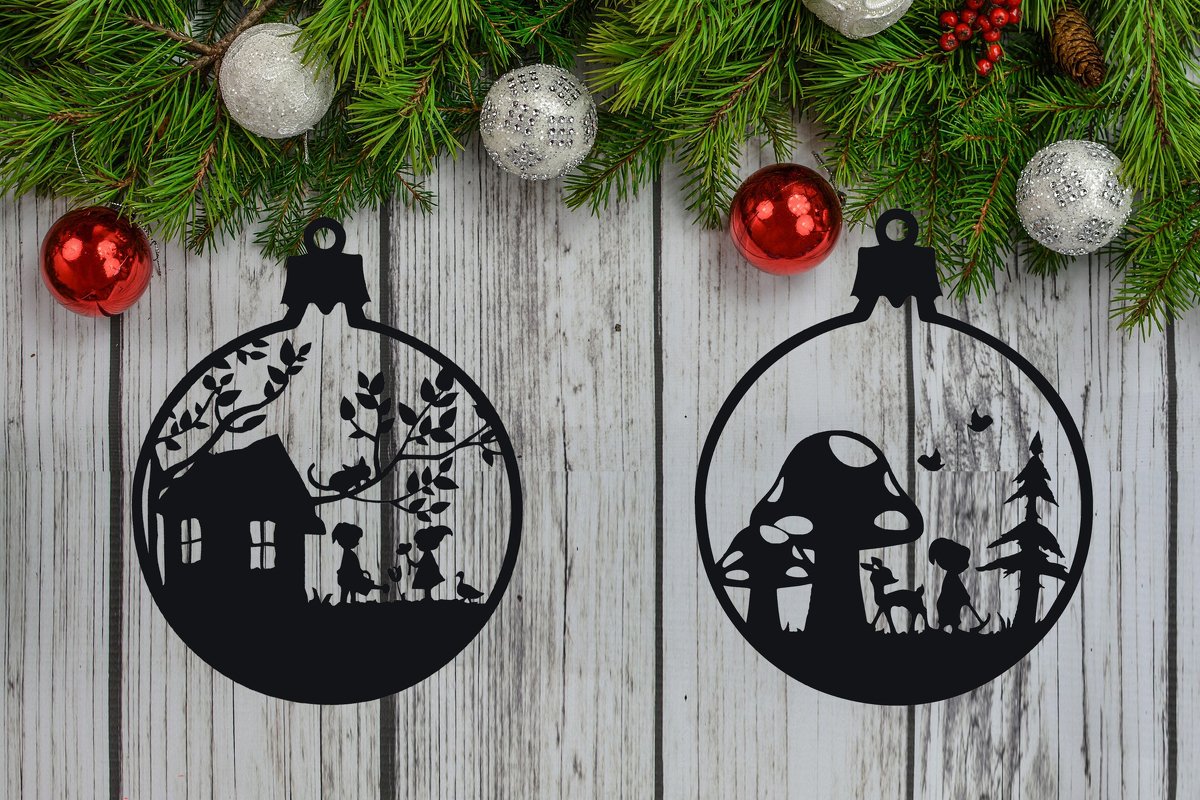 Zwei schwarze Silhouetten in Form von Weihnachtskugeln: links Haus mit Kindern und Bäumen, rechts Pilze mit Reh und Kind, vor Holzuntergrund und Tannenzweigen.