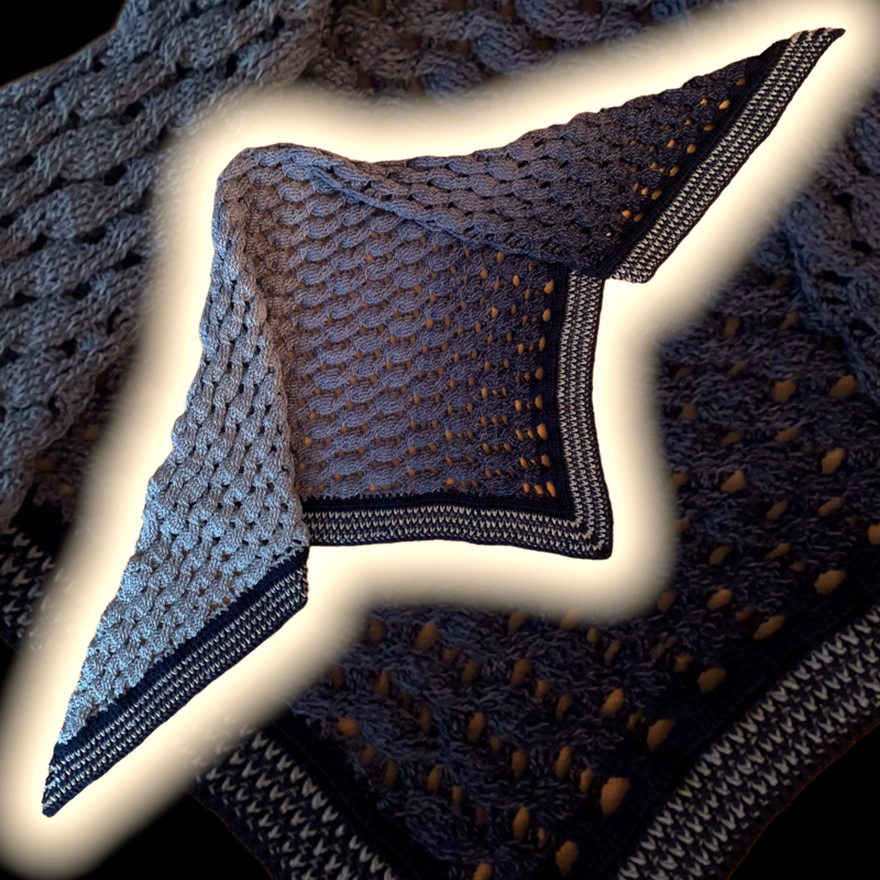 Crocheted triangle shawl with a blue gradient and patterned edges