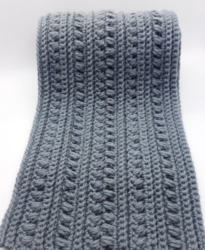 Grey crocheted scarf with rib and bobble stitch texture