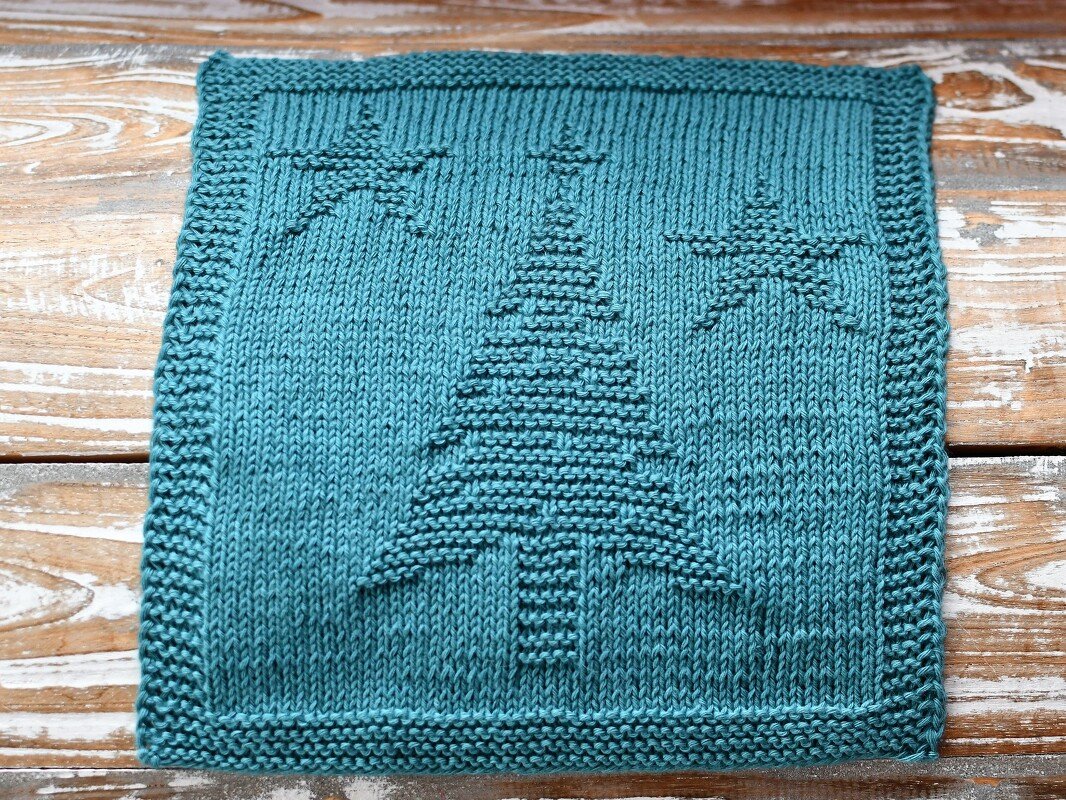 Teal knitted square panel with raised garter-stitch Christmas tree and two stars on a stockinette background