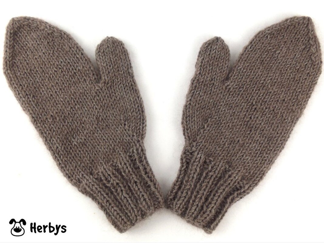 Paar braune gestrickte Fäustlinge mit Daumen auf hellem Hintergrund.