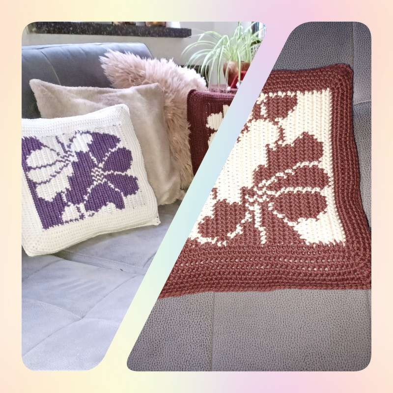 Zwei gehäkelte Kissenbezüge mit Blumenmotiv (Lila‑Weiß und Braun‑Weiß) auf grauem Sofa