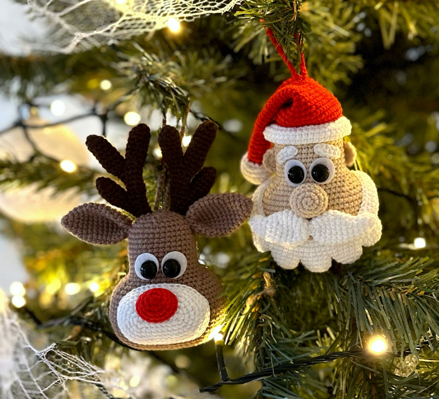 Gehäkeltes Rentier und Weihnachtsmann als Christbaumschmuck an einem Tannenbaum.