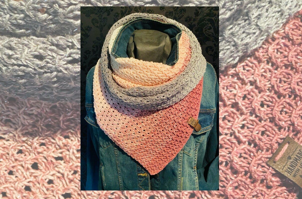 Gestricktes Dreieckstuch in Rosa und Grau mit Lochmuster auf einer Schaufensterpuppe mit Jeansjacke