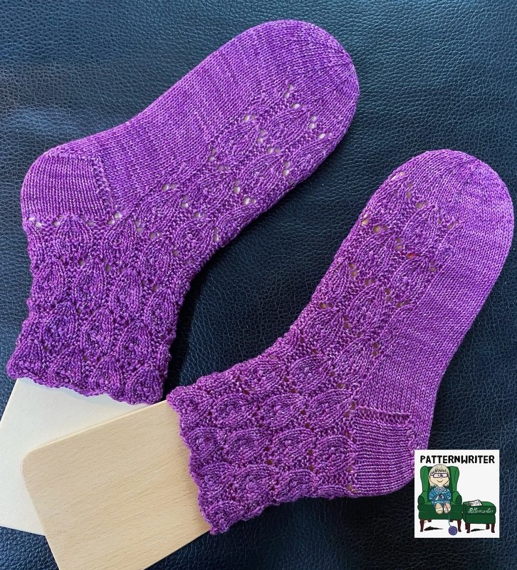 Lila gestrickte Socken mit dekorativem Loch- und Wellenmuster am Schaft.