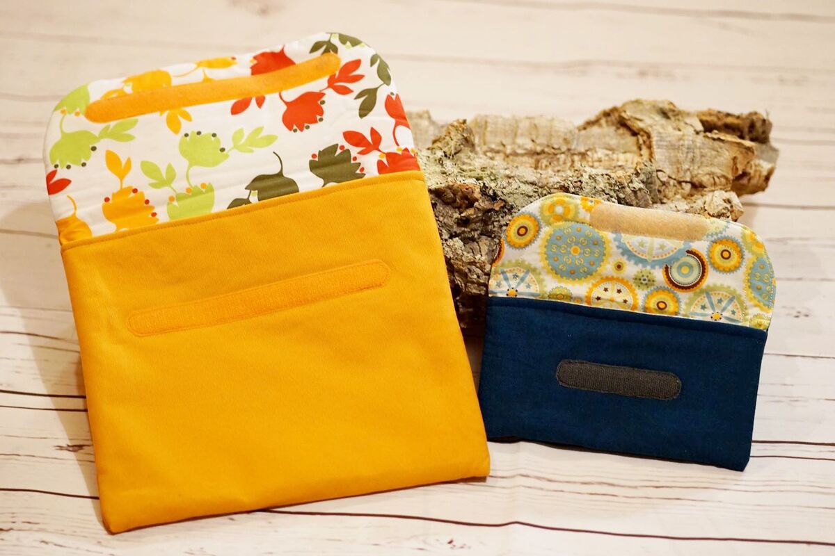 Gelbe Utensilo-Tasche und kleine blaue Stoff-Geldbörse mit gemusterter Klappe und Klettverschluss