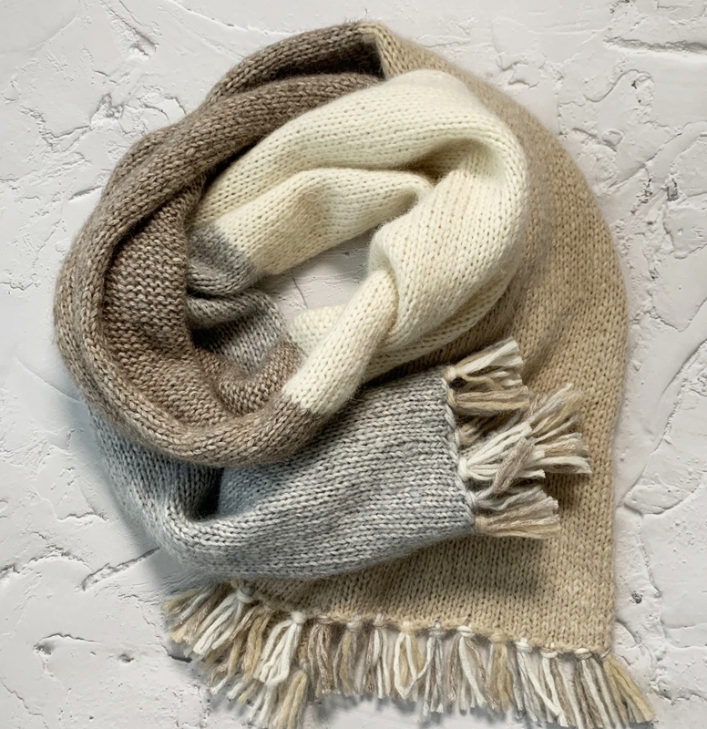 Mehrfarbiger gestrickter Loop-Schal in Beige, Creme und Hellgrau mit Fransen, aufgerollt