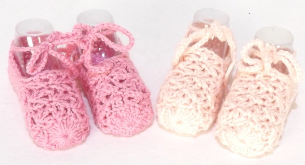 Zwei Paare zarter gehäkelter Babyschuhe in Rosa und Creme