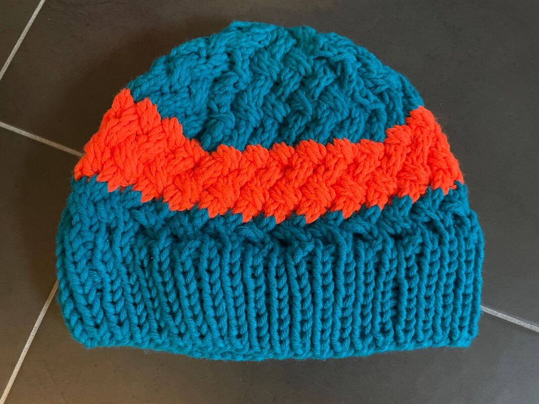 Türkis‑orange Strickmütze mit Zopf- und Rippenmuster