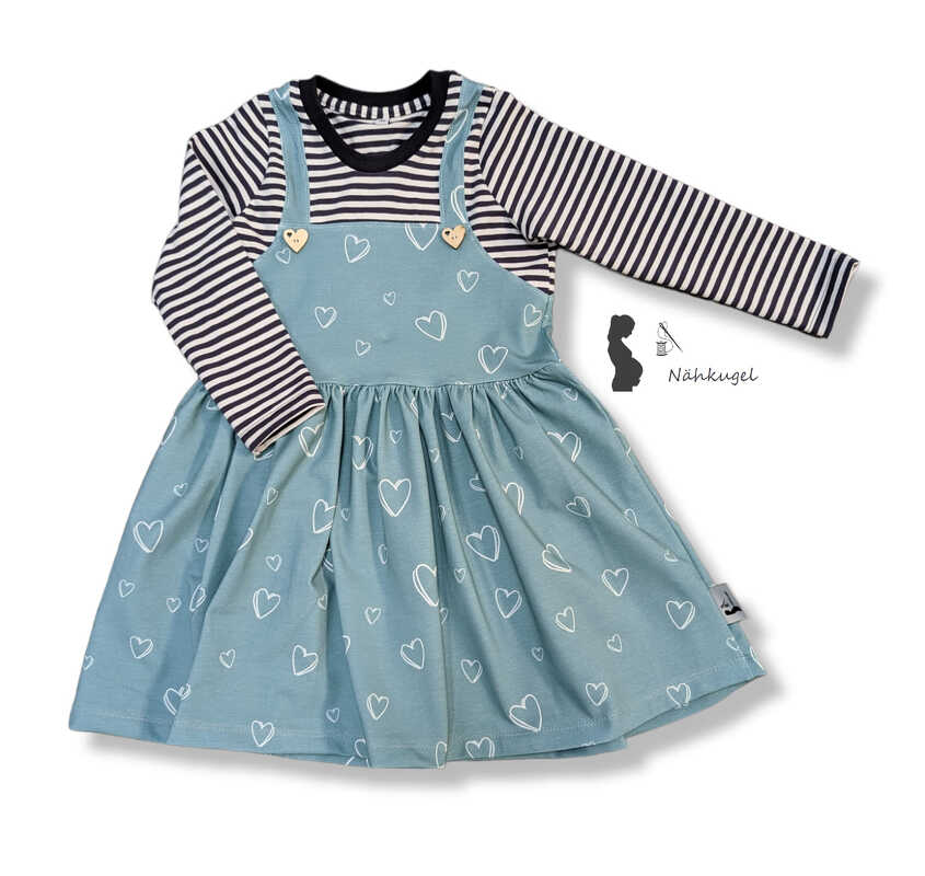 Latzkleid mit gerafftem Rock und Herzknöpfen über langärmligem Ringelshirt
