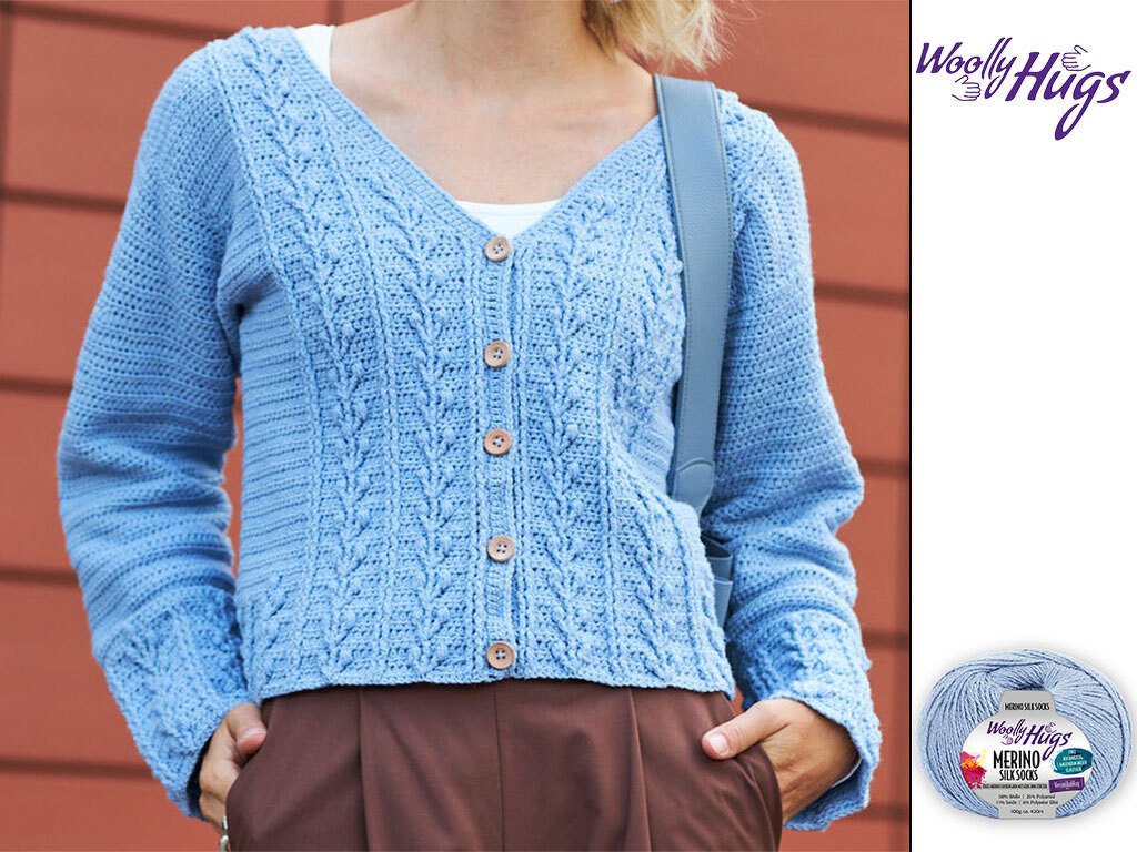 Person trägt hellblaue gehäkelte Jacke mit V-Ausschnitt und Holzknöpfen