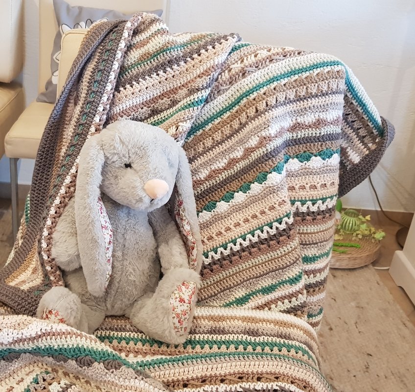 Gehäkelte Decke in Beige, Braun, Grau und Petrol mit Streifenmuster und Plüschhase