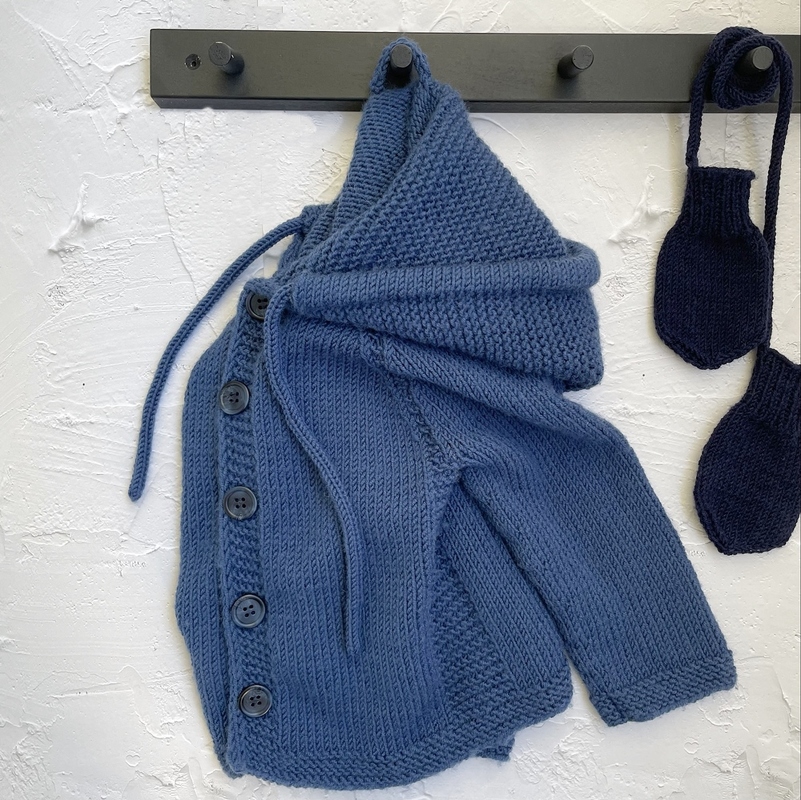 Handgestrickte blaue Kinderkapuzenjacke mit Knopfleiste und passenden Fäustlingen.